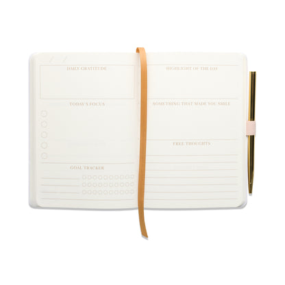 Introducing the “Gratitude Journal with Pen - Pause”: an inviting guided journal featuring a tan ribbon bookmark, elegant gold pen, and thoughtfully labeled sections for gratitude, focus, goals, highlights, smiles, and free thoughts. With mostly blank pages, it’s perfect for beginning your mindfulness journal practice.
