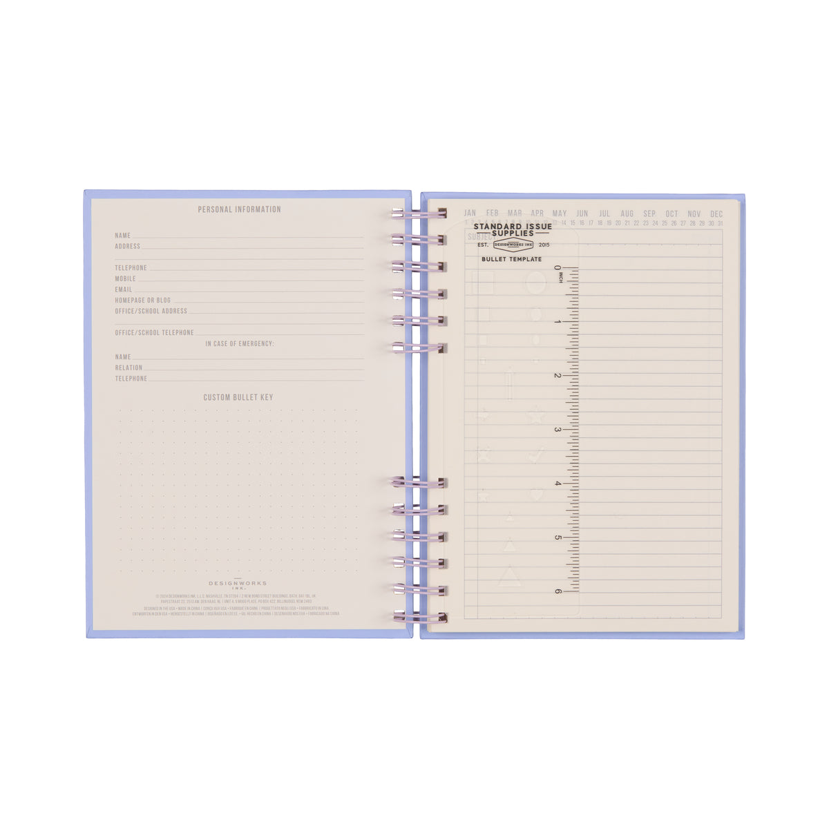 The Standard Issue Planner Notebook No. 12 - Lavender + Periwinkle features an open spiral-bound design, displaying a personal information page on the left and a yearly overview with monthly layouts and a bullet journal template on the right. Its cream-colored pages with gray text and dotted grids provide a premium writing experience.