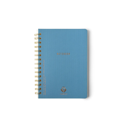 The Textured Paper Twin Wire Notebook - Small Blue features a softcover with "NOTEBOOK" in gold, rounded corners, a small emblem at the bottom center, and sits against a plain white background.