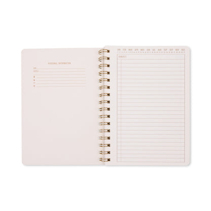 An open Tulip Twin Wire Notebook - Small Green Lattice is displayed, showcasing a personal information page on the left and a lined subject page with dates and months at the top on the right. Both pages feature a minimal, clean design accented by subtle botanical elements.