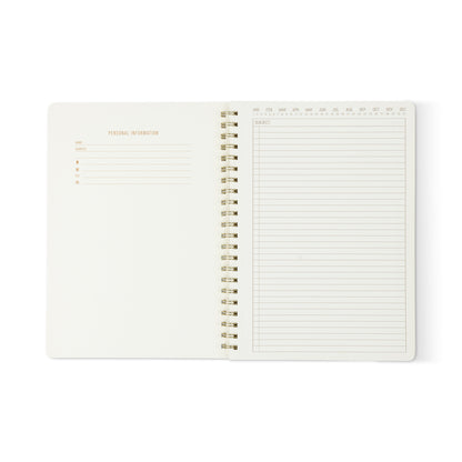 The Textured Paper Twin Wire Notebook - Large Lilac is open, showing a Personal Information form on the left and a lined, undated planner page with monthly calendar and Subject header on the right; most pages are blank.