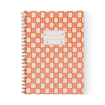 The Tulip Large Twin Wire Notebook - Orange Check features an orange and pink geometric cover, sturdy twin-wire binding, a white label for names or subjects, and lined perforated pages for easy tear-out.