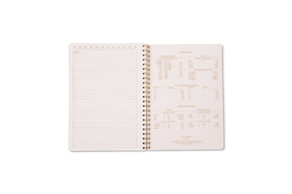 A Tulip Large Twin Wire Notebook - Orange Check lies open on a white background, showing lined perforated pages on the left and reference charts with measurements and conversions on the right.