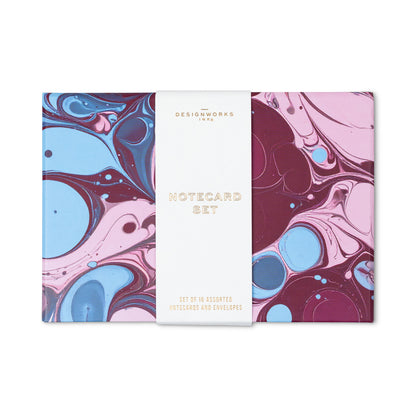 Boxed Marble Notecard Set - 16 Cards in a gift-ready box, featuring colorful marbled patterns in shades of blue, pink, and deep red, wrapped in a white paper band with gold text.