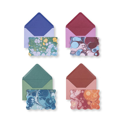 Four scalloped-edge notecards with colorful marbled patterns, each paired with a matching colored envelope in this Boxed Marble Notecard Set - 16 Cards.