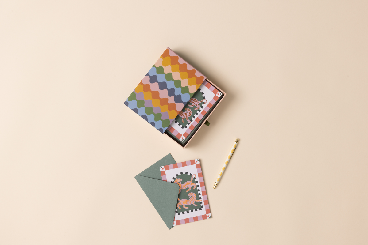 colorful boxed notecard set with letter and card on beige background