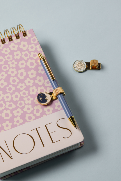 Notebook with floral design and charms on a light blue background