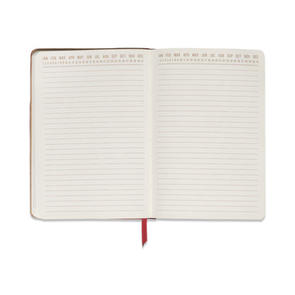 Introducing the Vegan Leather Pocket Journal in Burgundy + Pink—an open colorblock notebook accented with a red ribbon bookmark. Each premium, blank page offers a smooth writing surface and features months from January to December along the top, with days numbered 1 to 31. Perfect for capturing your notes and ideas in style.