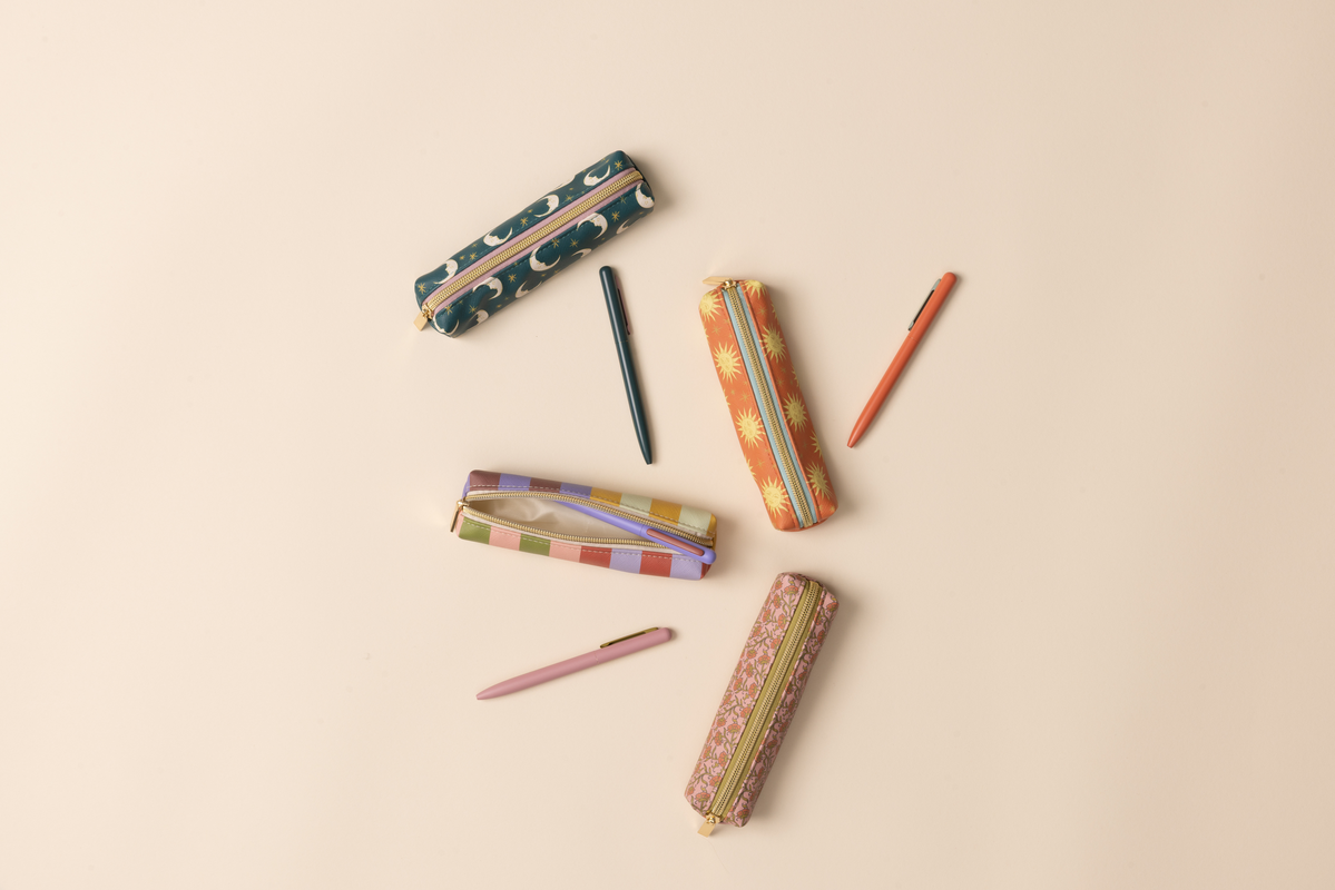 Colorful pencil cases and pencils on a beige background