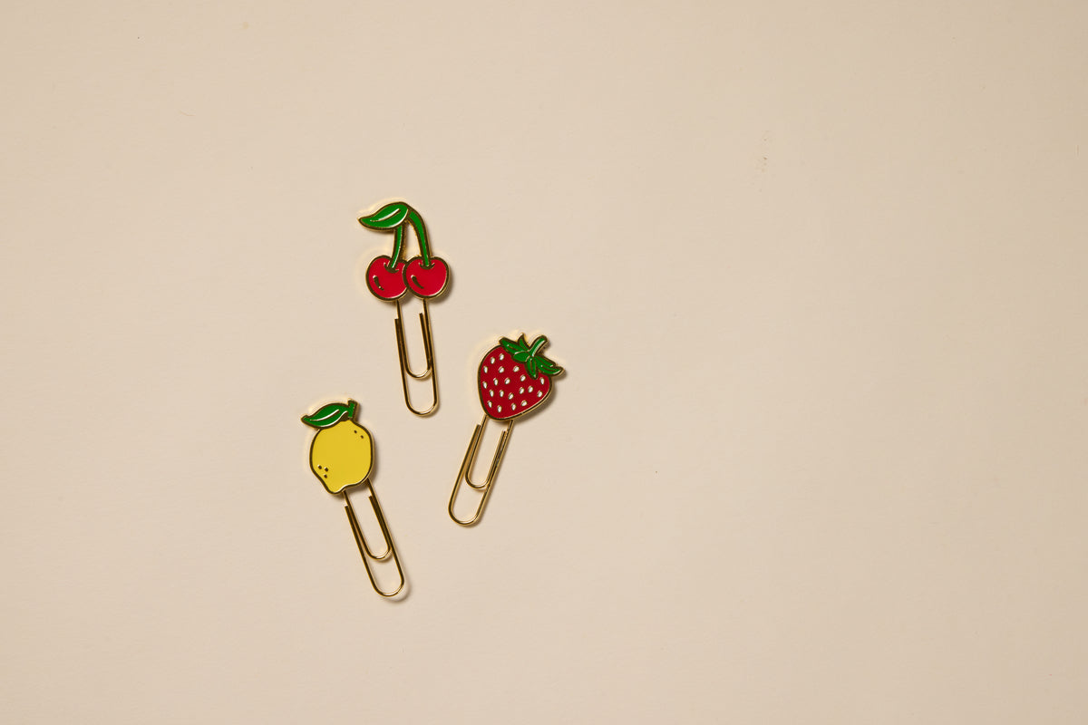 The Set of 3 Paperclips - Fruit features gold clips topped with cherry, strawberry, and lemon decorations, perfect for adding charm to your planner or using as fun office accessories.