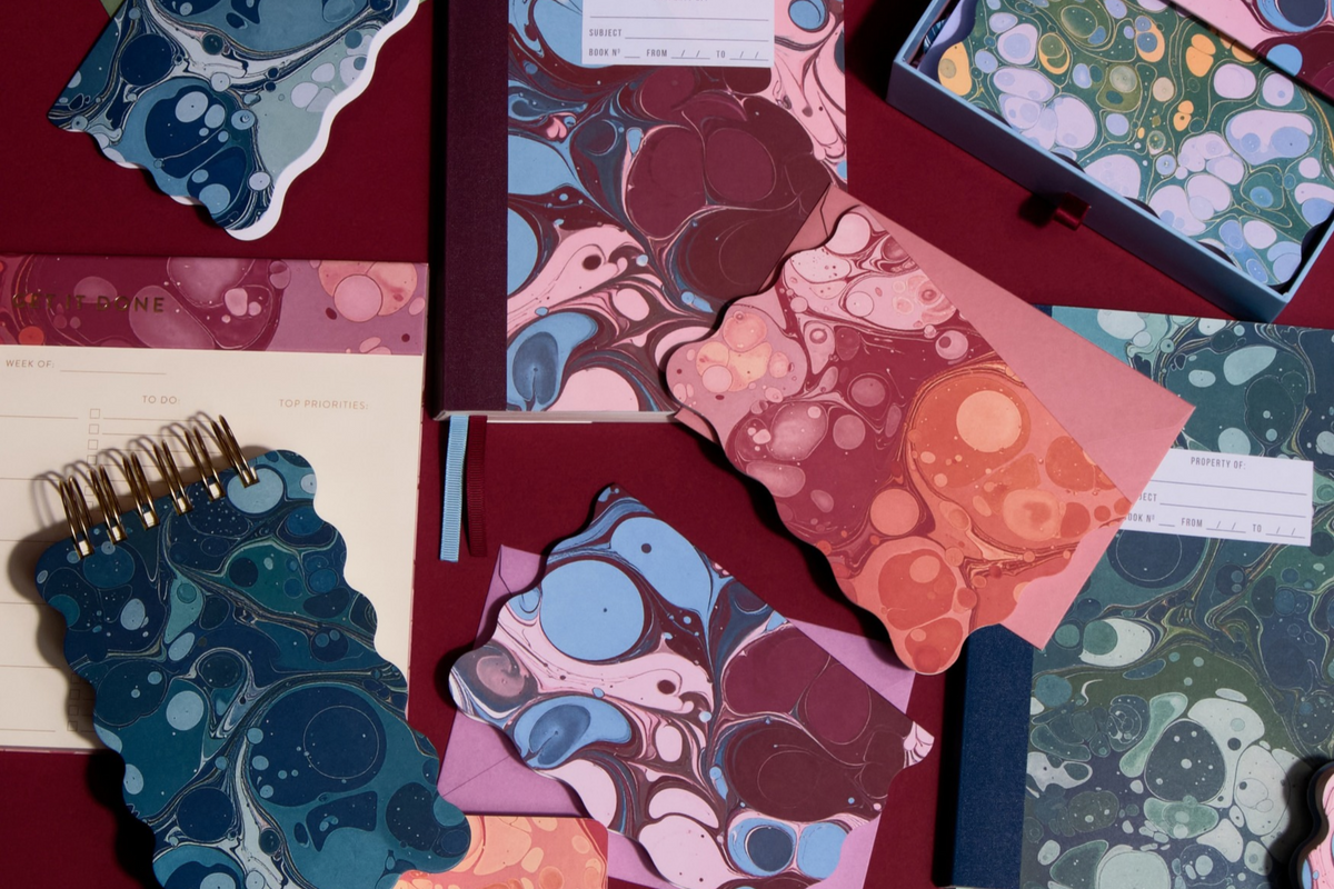 Assortment of journals, notepads, and planners in Marble collection.