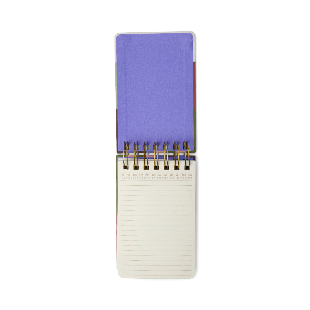 The Chunky Small Twin Wire Notepad – Bold Stripes is open to reveal a blank lined page at the bottom, while its bold, colorful hard cover rests on top, all set against a clean white background.