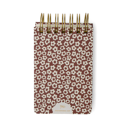 Introducing the Chunky Small Twin Wire Notepad in Burgundy Groovy Floral—a compact, spiral-bound notepad with a sturdy burgundy cover adorned with a playful floral pattern and a gold logo at the bottom center. With 192 sheets inside, it’s perfect for jotting down notes wherever you go.
