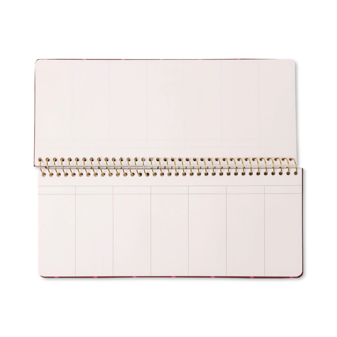 A Color Block Weekly Planner Pad - Burgundy + Pink, featuring an open spiral-bound design with blank, off-white pages sectioned into rectangles for each week, is photographed from above on a white background.