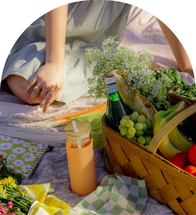 A powered women having a picnic with Notebooks and a bottle with a straw