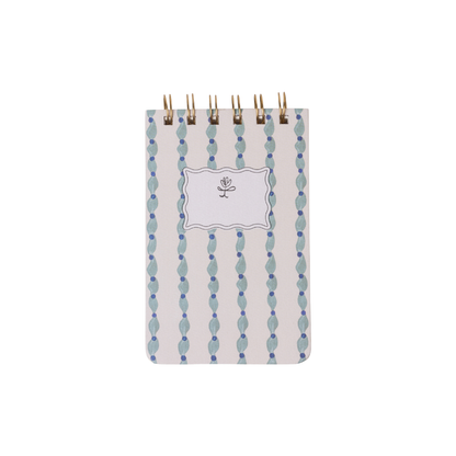 The Tulip Twin Wire Notepad - Wavy Blue is a compact notepad with lined pages, a blue and white wavy pattern cover, and a blank label featuring a simple flower illustration.