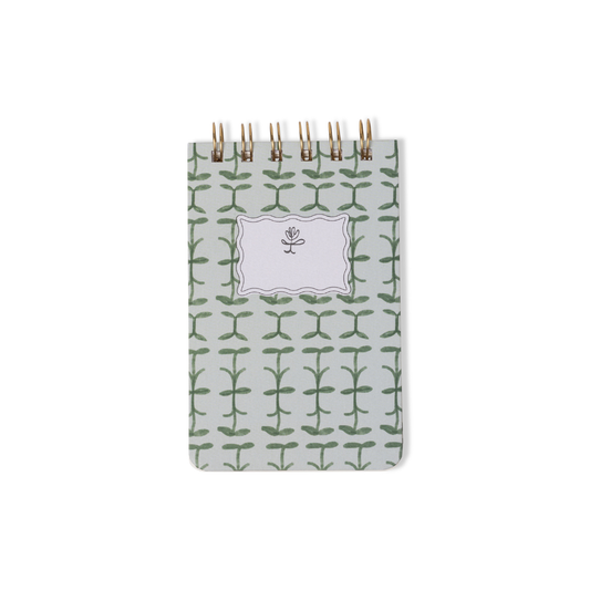 The Tulip Twin Wire Notepad - Green Vine is a small notepad featuring a green vine pattern on the cover with a central label displaying a minimalist tulip illustration.