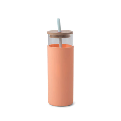 The Tumbler With Straw - Mint/Peach features a tall, clear glass body, peach silicone sleeve, bamboo lid, and a light blue straw. Its modern colorblock design offers a stylish and eco-friendly drinkware option with minimalistic vibrant accents.