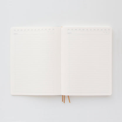 The Standard Issue Project Notebook No.4 - Black features acid-free lined pages and two ribbon bookmarks, shown open from above on a white background.