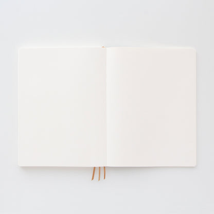The Standard Issue Project Notebook No.4 - Black, featuring acid-free paper and three ribbon bookmarks, rests on a white surface—ready to capture your thoughts.