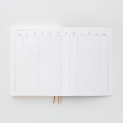 The Standard Issue Project Notebook No.4 - Black features a flexible cover and acid-free paper with a blank yearly calendar spread, columns for each month, rows for important dates, and two ribbon bookmarks.