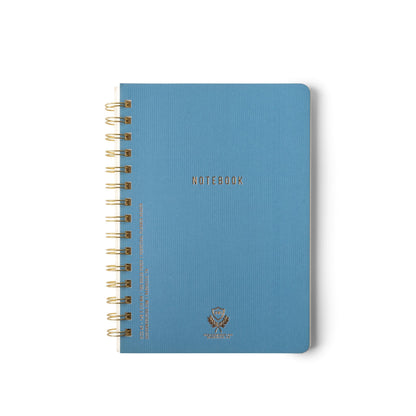 A Textured Paper Twin Wire Notebook - Medium Blue with gold NOTEBOOK lettering on the flex cover, photographed against a plain white background.